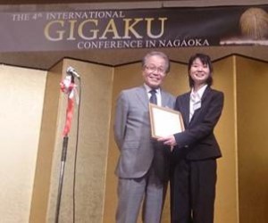 長岡技術科学大学の新原学長(写真左)より優秀ポスター賞の表彰をうける笹本さん(写真右)